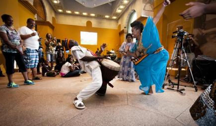 Man and woman dancing before smiling audience in Oman