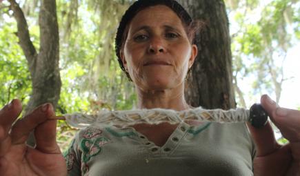 Taino healer spinning cotton from her garden