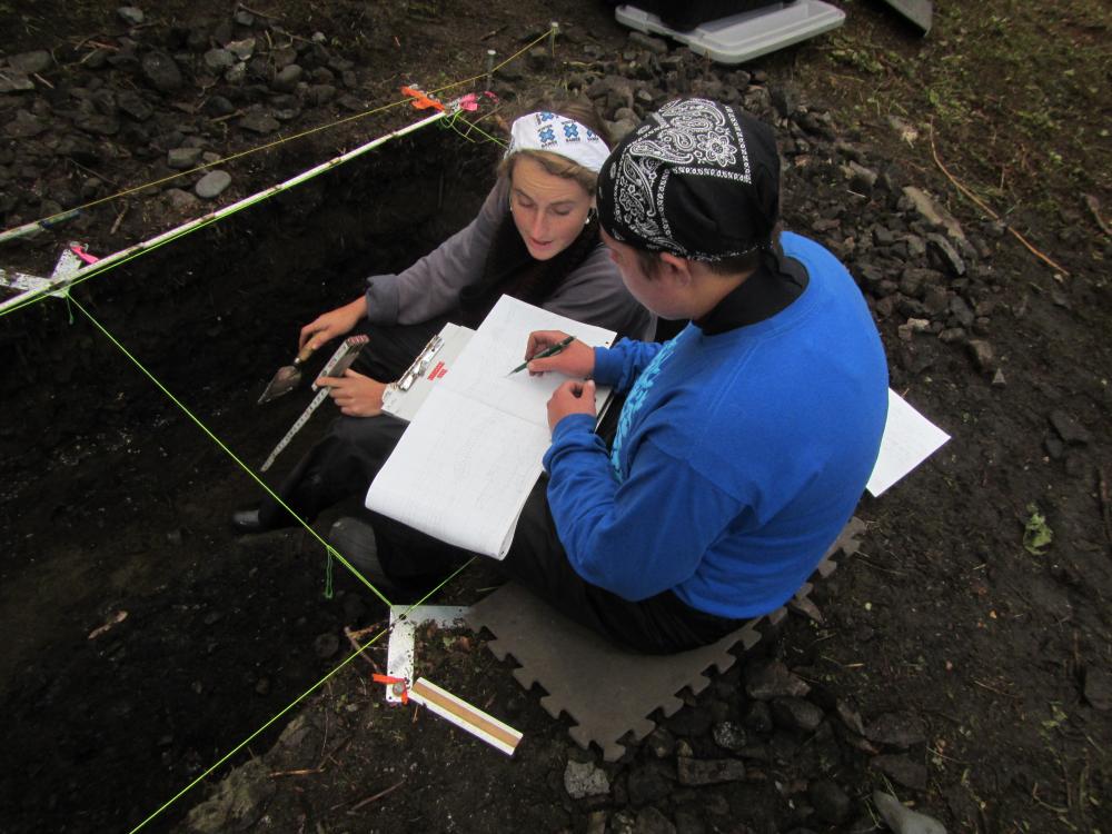 Students excavating seal bones at the Old Town archaeological site, Knight Island, Yakutat Bay (2014). Photo credit: Aron Crowell.	